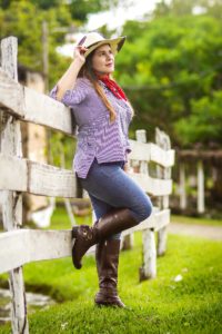 Image of a farm woman leaning on a fence.