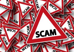 SCAM on a red and white triangular sign