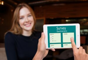 woman watching someone take a survey on a tablet