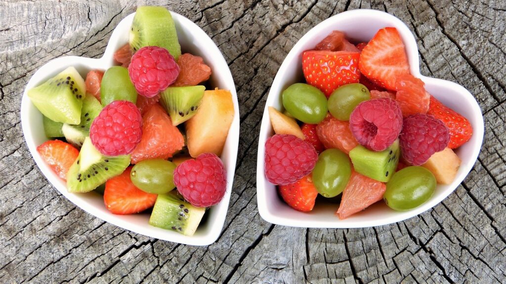 2 heart-shaped bowls of fresh fruit