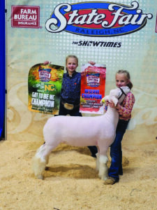 girls showing winning sheep at the fair