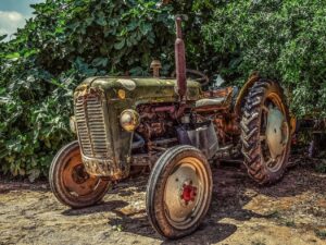 green tractor iin front of woodline mage by Dimitris Vetsikas from Pixabay