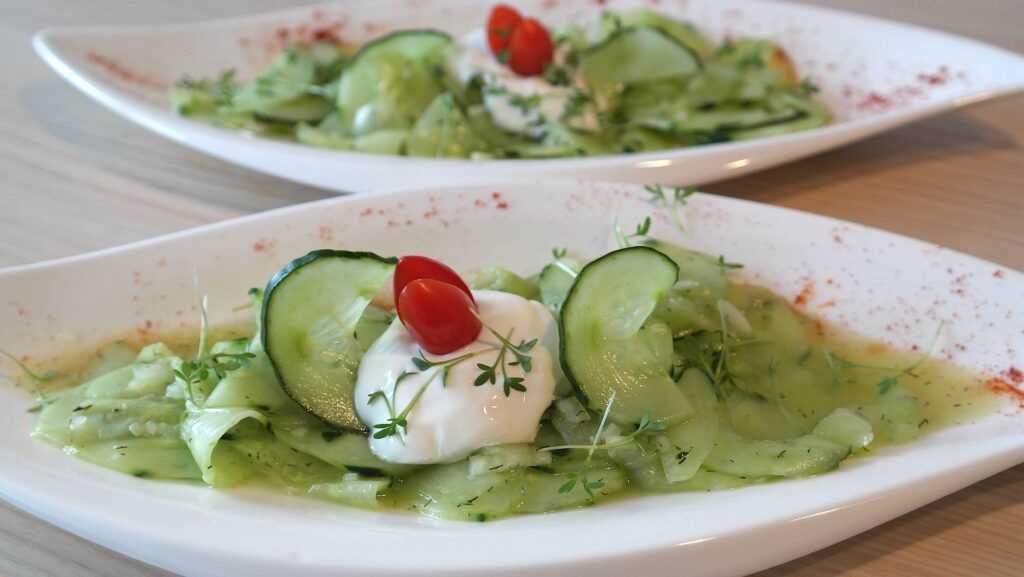 image of 2 white bowls of cucumber salads